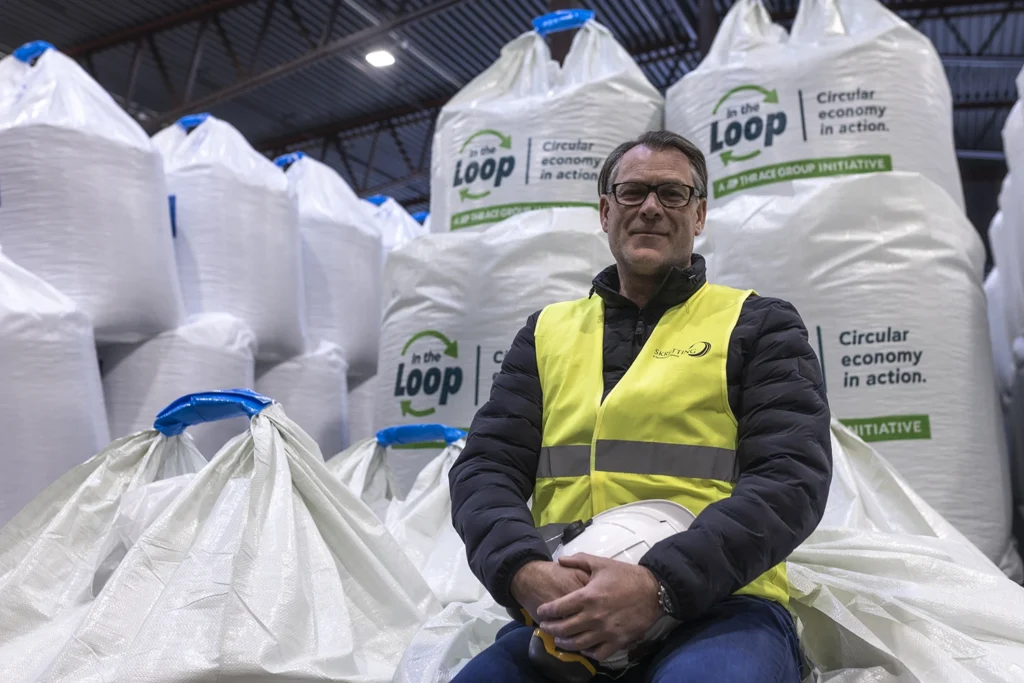 Storkundeansvarlig og prosjektleder Ronny Halland avbildet foran "IN THE LOOP"-sekker på lageret til Skretting, en av verdens største produsenter av fiskefor.